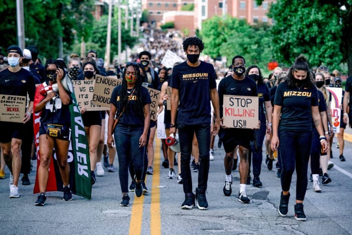 In September, sprinter Suggs (center) led a march of Tigers athletes and their supporters.